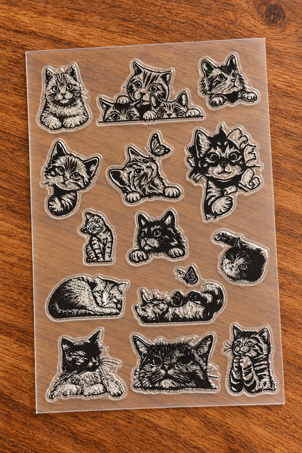 A sheet of clear plastic craft stamps featuring multiple illustrated cat faces and paws.