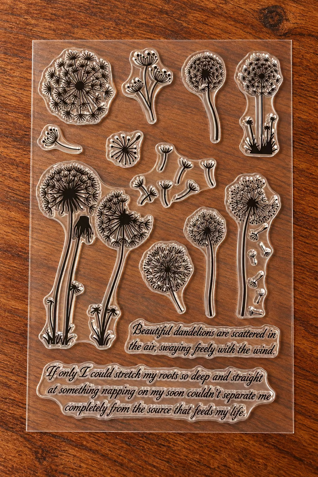 A sheet of clear acrylic or rubber stamp designs featuring dandelions and script text phrases