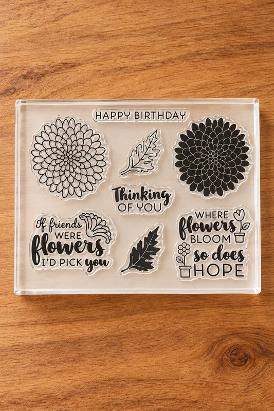 A clear stamp set on a white backing sheet, featuring florals and quote designs,