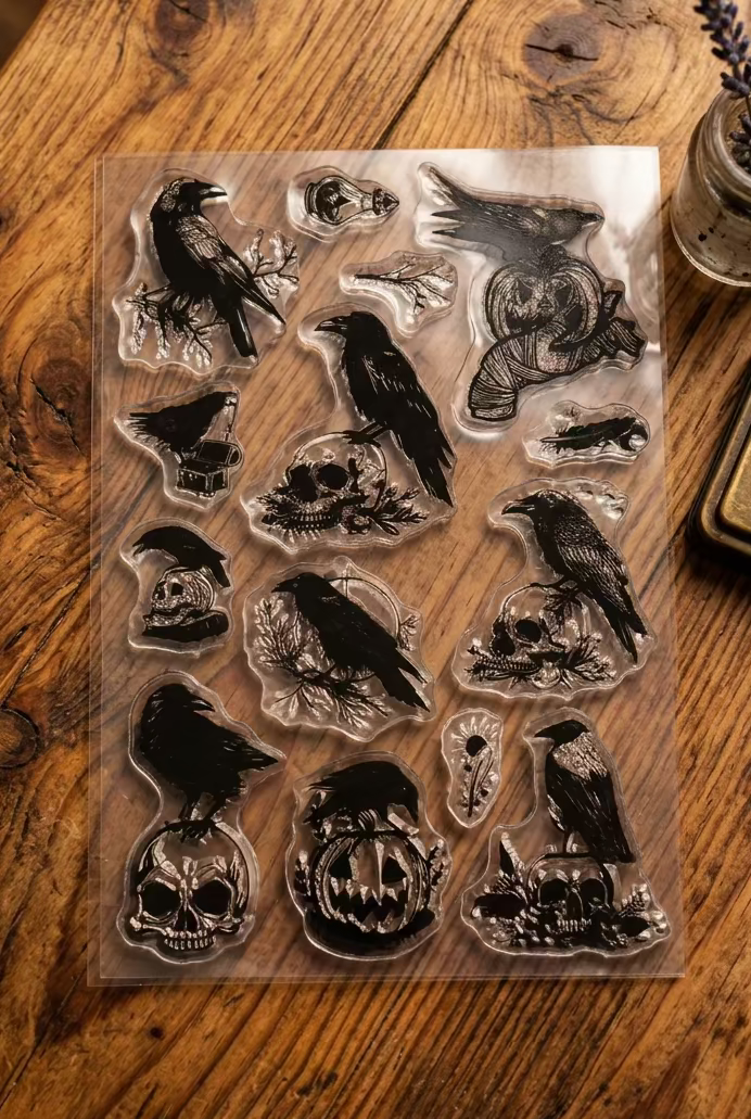 clear plastic craft stamps featuring black crow and raven designs with skulls, pumpkins, and leaves.